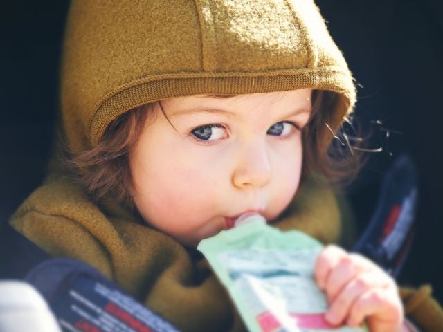Child drinking fruit pouch